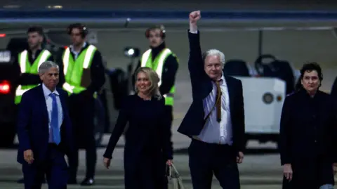 Reuters Julian Assange waves after landing in Australai