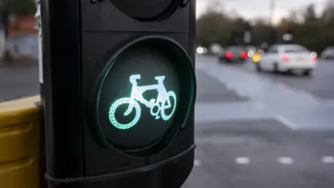 Getty Images An illuminated cycle lane sign with cars in the background