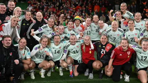 Players of Wales pose for team a photo following victory in the UEFA Women's EURO 2025.
