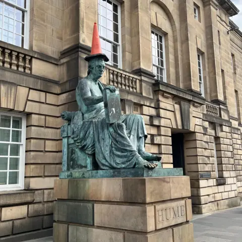 The David Hume statue on the Royal Mile with a cone on its head.