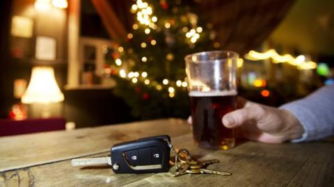 A pint of beer next to a set of car keys