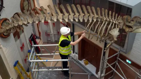 PA Media Overhead shot of work taking place at the museum. There is scaffolding in place and other items on the wall, including a ship's wheel.