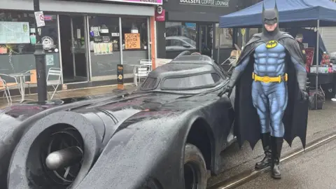 Fleetwood Arts CIC A man dressed as Batman beside the Batmobile
