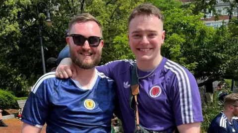 Two men wearing Scotland strips.