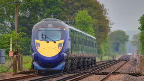 A fast, blue Southeastern train heading out of Ashford in Kent.