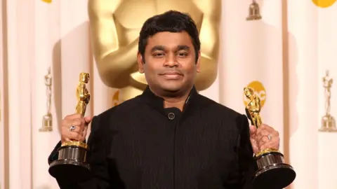 Getty Images AR Rahman, a man wearing a black outfit, holding the two golden Oscars he won in 2009 for the film Slumdog Millionaire