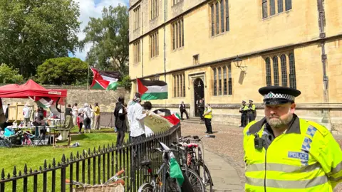 Policeman and protesters oustide radcliffe camera