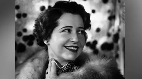 Yvonne Arnaud wearing a necklace with pearls