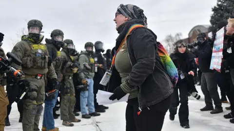 A protester (centre) shouts towards a line of federal law enforcement agents during an anti-ICE demonstration outside the Bishop Whipple Federal Building in Minneapolis, Minnesota