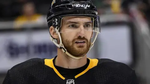 Getty Images Adam Johnson in ice hockey kit looking into the distance