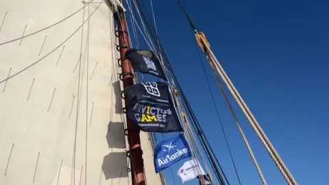 A view of the flags near the sails of the ship. 