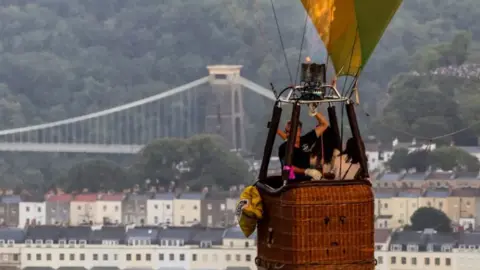 Reuters A close-up in the sky of people travelling in a hot air balloon with the Clifton Suspension Bridge in the background