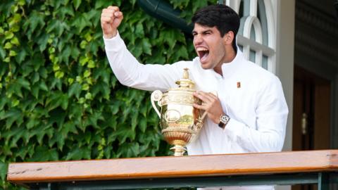 Carlos Alcaraz celebrates with the Wimbledon trophy
