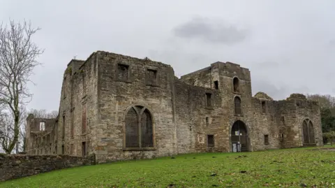 Brian Deegan/Geograph Workington Hall, which is the ruins of a castle, on a cloudy day.