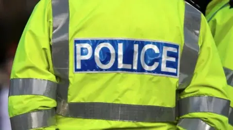 Getty Images A police officer with their back to the camera in a hi-viz police jacket.