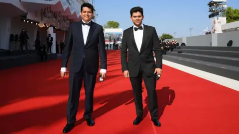Getty Images Director Chaitanya Tamhane (L) and Aditya Modak (R) walk the red carpet ahead of the movie "The Disciple" at the 77th Venice Film Festival at on September 04, 2020 in Venice, Italy.