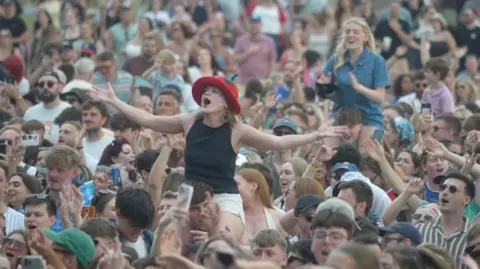 Jamie Niblock/ BBC More festival goers in the crowd at Halo Festival.