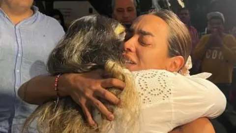 The boy's mother is seen embracing another woman in this photo released by the mayor's office