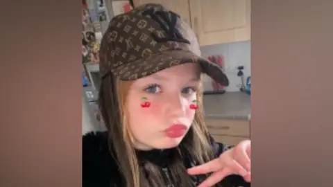 Family Handout A girl wearing a baseball cap and posing for the camera in a selfie-style image.