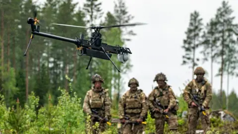 British Army soldiers from 3 Rifles watch a single-rotor helicopter style Ghost drone on exercises in Finland 