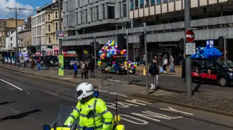 Mark Forsyth A uniformed police officer on a motorbike stops traffic on Princes Street in Edinburgh
