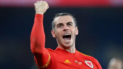 Gareth Bale punches the air and shouts in celebration