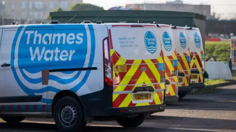 A row of four Thames Water vans parked up.