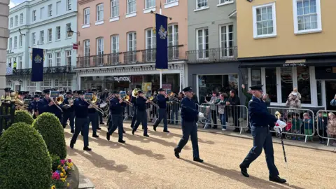 A marching band rehearsing in the streets of Windsor.