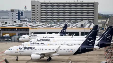 Parked Lufthansa aircraft are lined up at Frankfurt Airport on April 13, 2026.