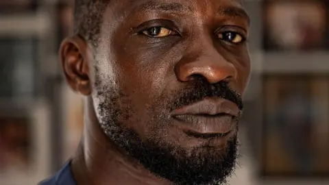 A close-up shot of a solemn Bobi Wine looking into the camera 