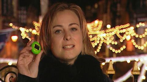 Presenter Philippa Forrester holding a green Tamagotchi.