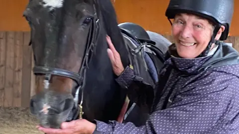 Woman smiling with a horse