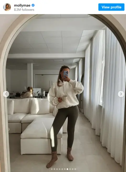 Molly-Mae Molly-Mae's Instagram. She is posing in the mirror holding a mug