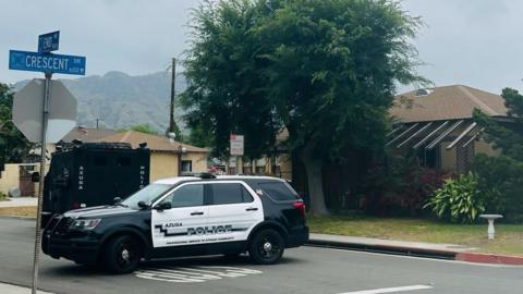 Azusa Police Department vehicle on the block of the home were a search warrant was executed