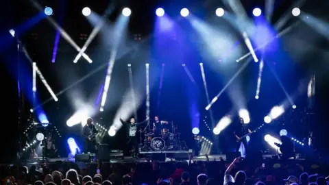 Getty Images Band playing on stage lit by multiple spotlights