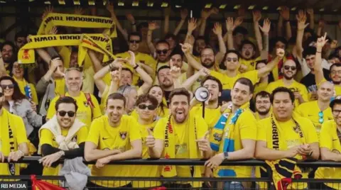 RB Media العشرات من مشجعي كرة القدم الإسبان يرتدون قمصان كرة القدم Harborough Town