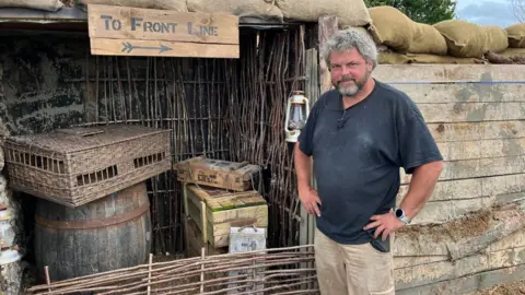 BBC Richard Dalton standing in front of a set wearing a dark t-shirt