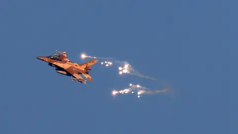 AFP via Getty Images An Israeli Air Force fighter jet fires flares to intercept an enemy missile launched from across the Lebanese border. Photo: August 25, 2024