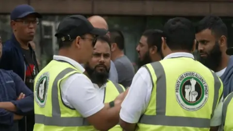 BBC Drivers in reflective bibs talk to one another at the protest on Wednesday