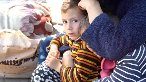 A child looks scared while a woman bends down next to him