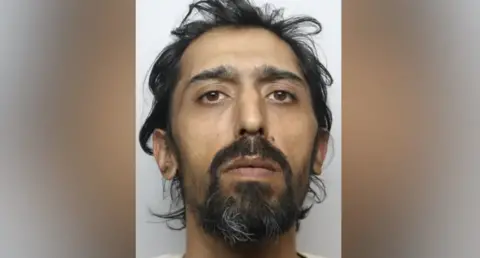 West Yorkshire Police A custody picture of a man with dark hair and a goatee style beard