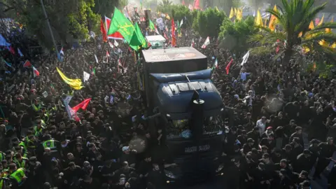 Getty Images Hundreds of people gathered as a truck carrying coffins including Ali Khamenei through Najaf, Iraq