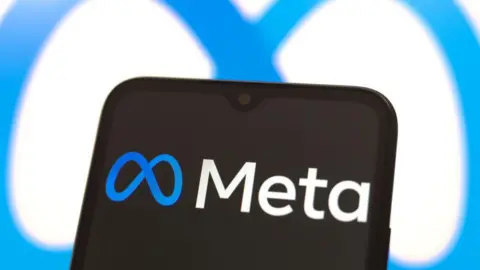 Getty Images Meta logo displayed on a black screen on a smartphone, with the company's loop logo shown on a white background behind it