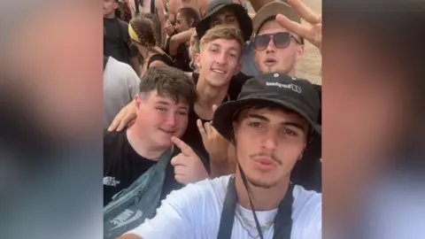 Adam is posing in a selfie with his new friends at the festival.
