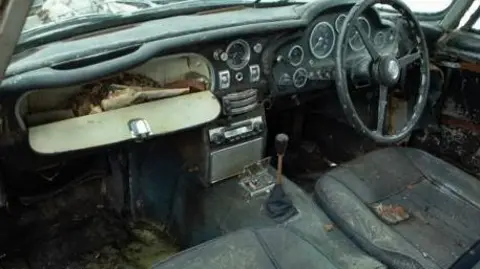 Marc Bow/Timbuktu Content Interior of the car as it was with dirty seats and lots of debris and papers in the glove box