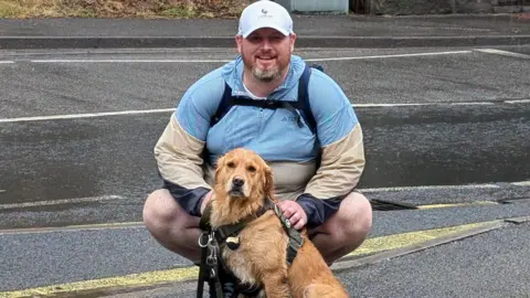 A man and his dog posing for the camera in Matlock Bath
