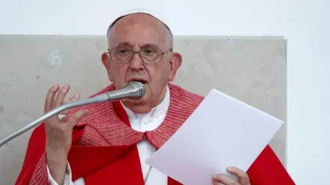 Reuters Pope Francis celebrates a ceremony. He is wearing a red robe.