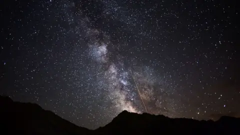The Perseids meteor shower with the Milky Way galaxy.