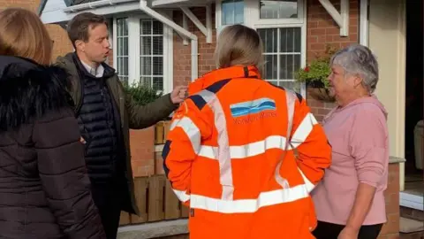 MP Jake Richards meets a Yorkshire Water representative and residents outside a house