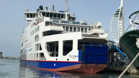 MV St Clare berthed at Gunwharf ferry port. It is a large white ferry with blue doors.